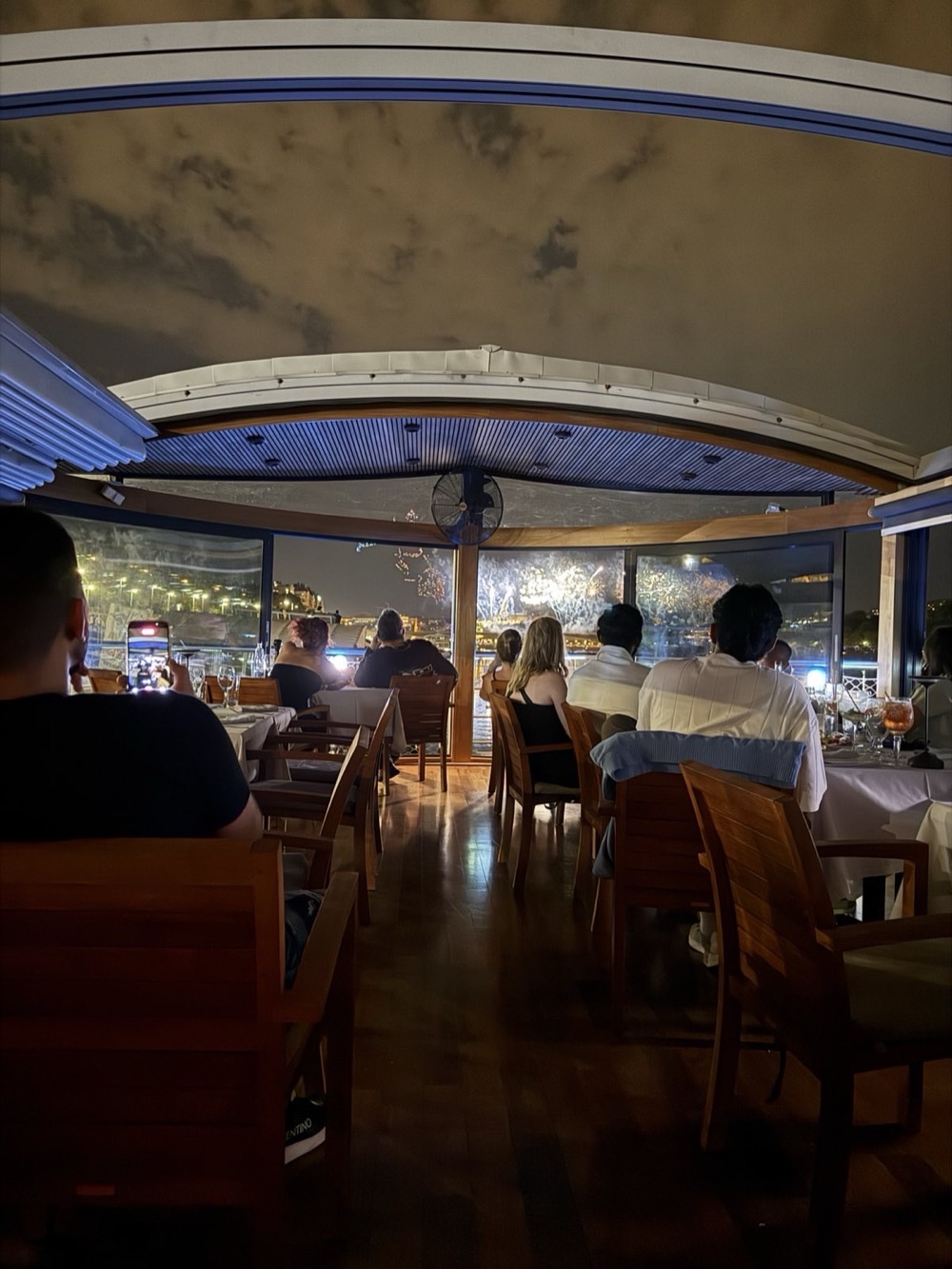Guests on the covered terrace watching the fireworks through the glass